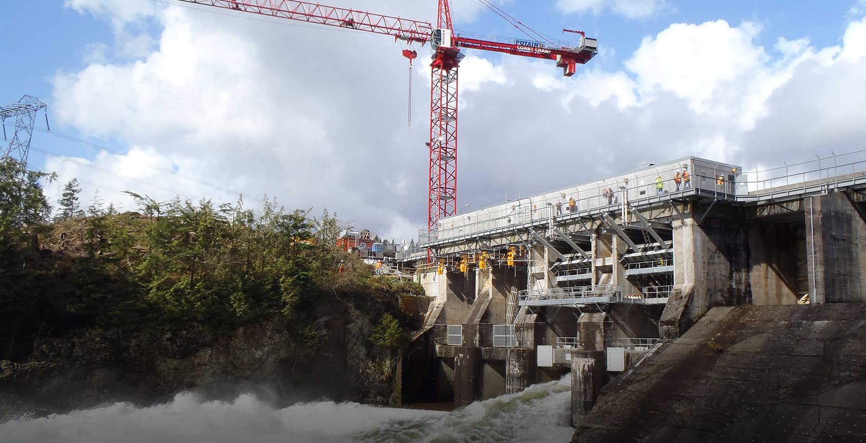 tower crane in picture of stave lake dam, water coming out spillway