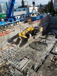 excavatorn lifted out of hole by crane